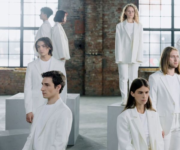 A diverse group of people sitting peacefully in a bright, modern studio.